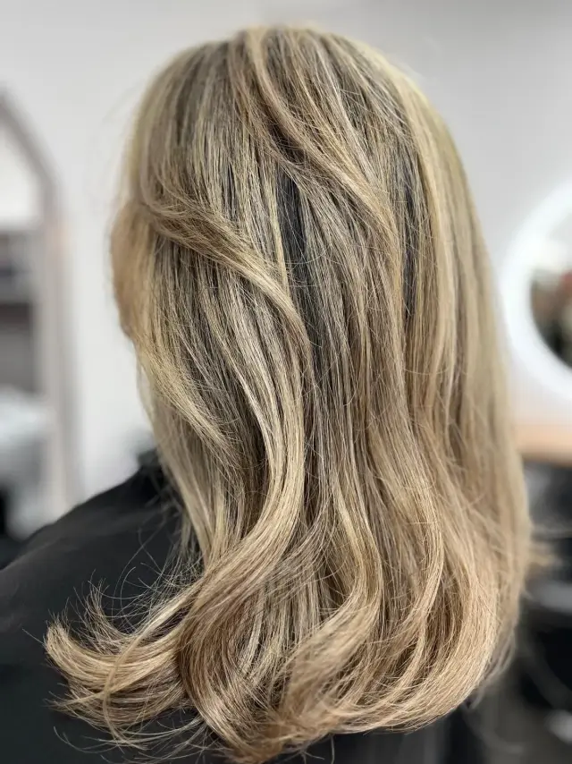 Balayage blond beige sur cheveux mi-longs ondulés – coiffure à Savigny-sur-Orge