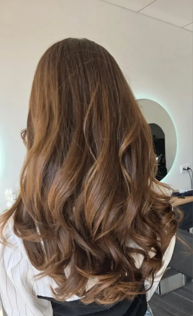 Balayage caramel sur cheveux longs bouclés – Atelier Coiffure Savigny-sur-Orge