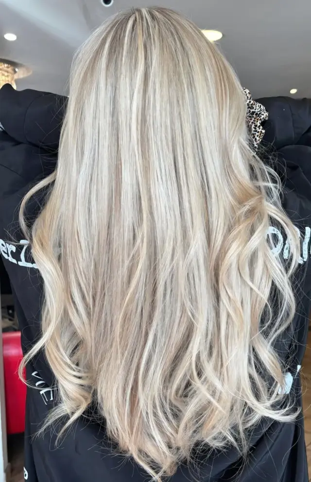 Blond polaire sur cheveux longs ondulés – salon de coiffure à Savigny-sur-Orge